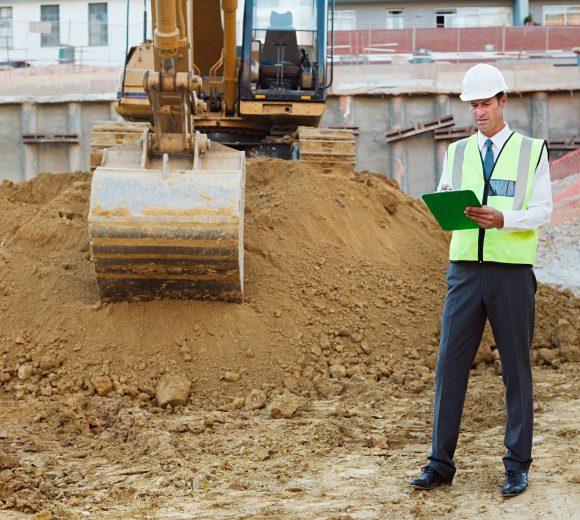 Mature man with clipboard on construction site